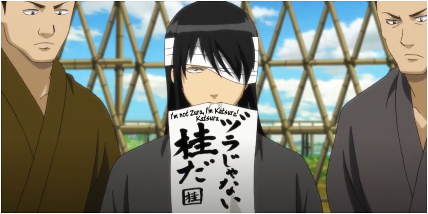 Katsura in Gintama holding up a paper that reads, "I'm not Zura, I'm Katsura!"