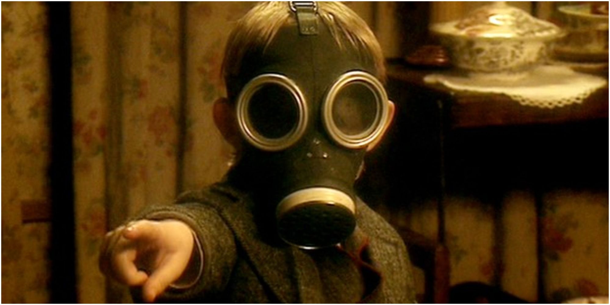 A small child in a gas mask points at the camera in Doctor Who.