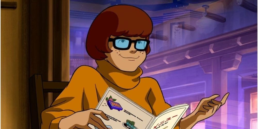Scooby-Doo Velma Dinkley smiles and reads