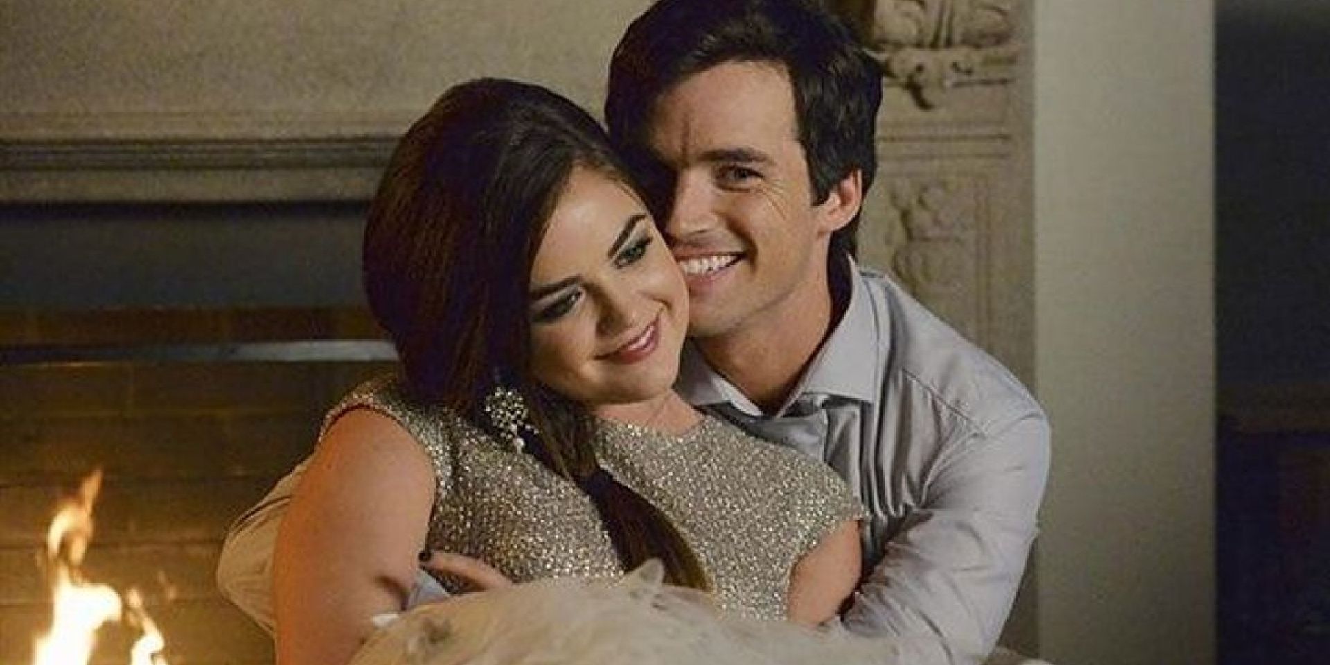 Aria and Ezra smile and cuddle by the fire on Pretty Little Liars