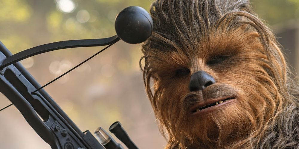 Chewbacca holding a crossbow in Star Wars.
