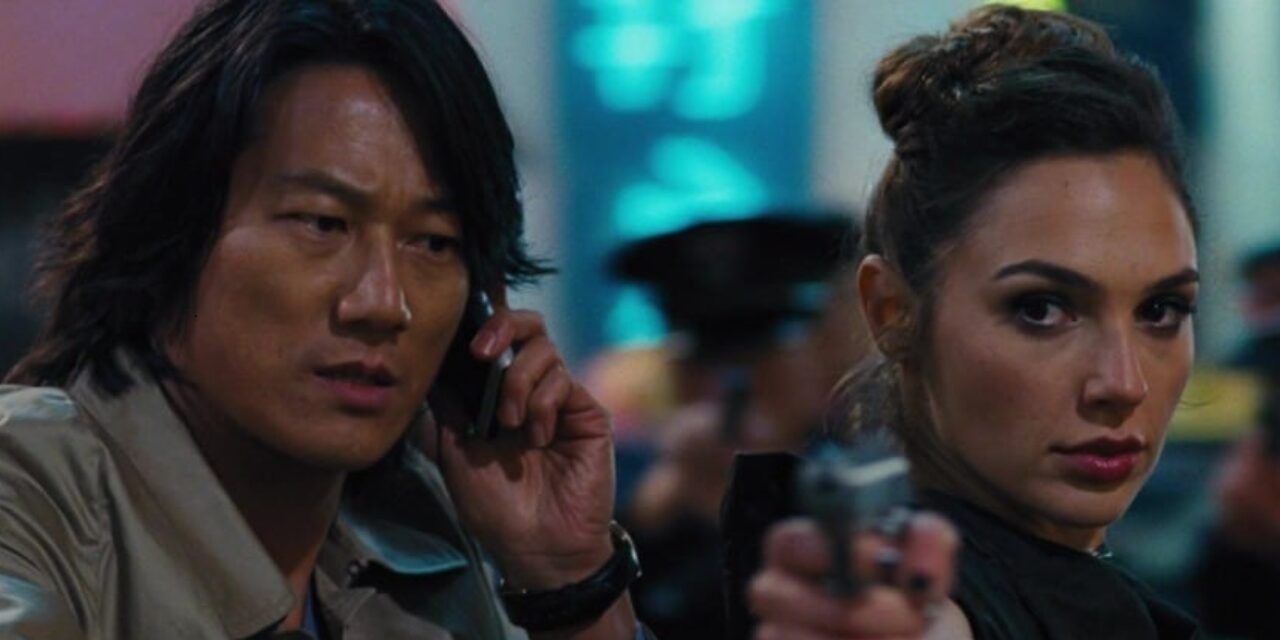 Gisele holding a gun and Han on the phone in Fast and Furious