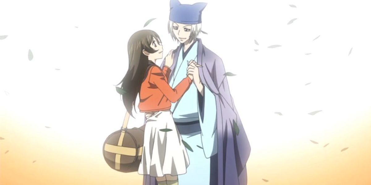 Image features a visual from Kamisama Kiss: (From left to right) Nanami Momozono (long, brown hair and reddish-orange jacket with white skirt) is holding Tomoe (silver hair, blue hat and light blue kimono)'s hand.