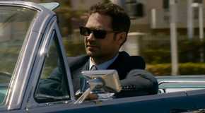 Mickey Haller drives his Lincoln convertible wearing sunglasses in Netflix's The Lincoln Lawyer