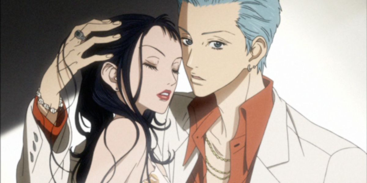 Image features a visual from Paradise Kiss: (From left to right) Yukari "Caroline" Hayasaka (long, black hair) is modeling with Joji "George" Koizumi (short, blue hair, white suit and orange dress shirt).