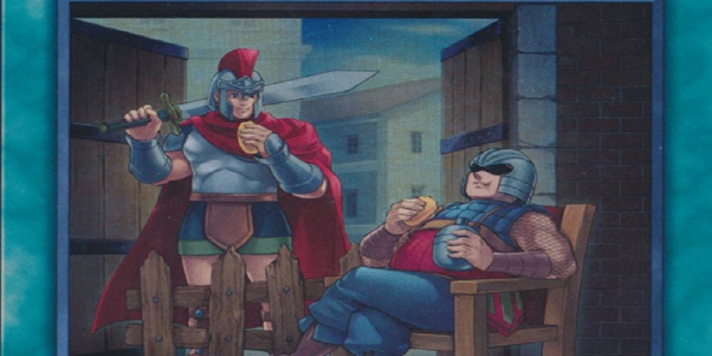 Two guards relaxing and eating, one standing up, one in a chair.