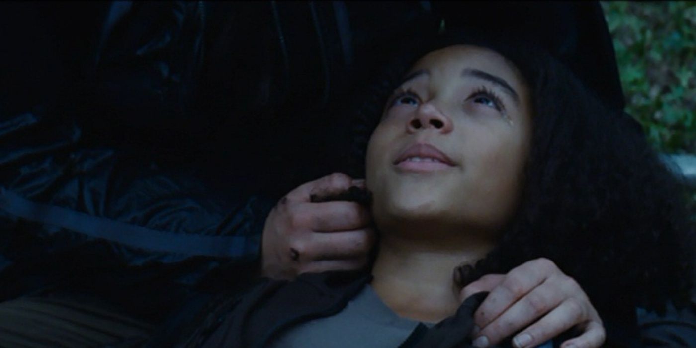 Rue (Amandla Stenberg) morre nos braços de Katniss (Jennifer Lawrence) em Jogos Vorazes.