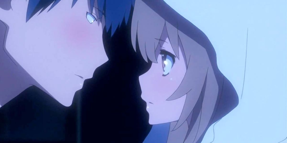 Image features a visual from Toradora: (From left to right) Ryuji Takasu (short, blue hair) is about to kiss Taiga Aisaka (long, brown hair with a white sheet on her head)