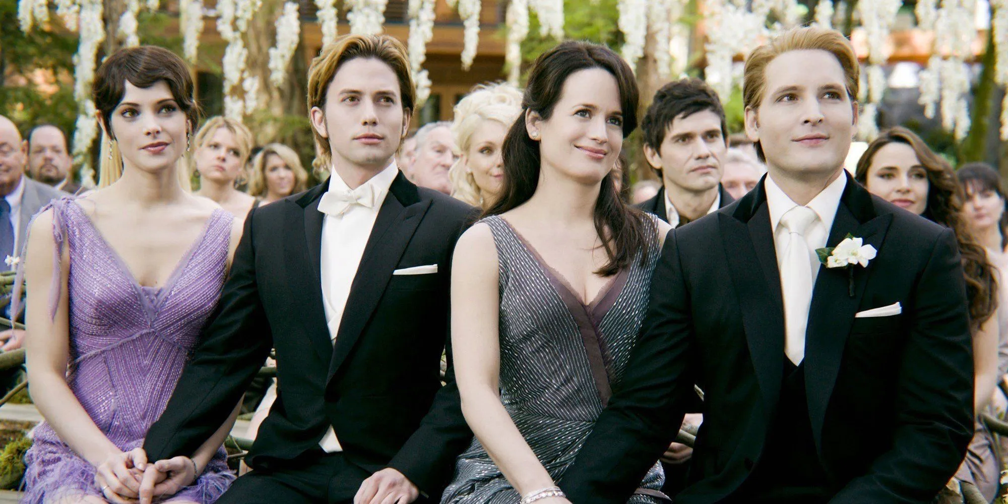 Alice, Jasper, Esme, and Carlisle holding hands and smiling at Bella and Edward's wedding.