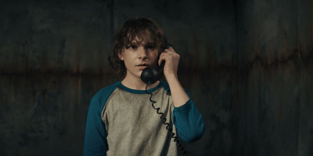 Finney talking on the strange black phone in The Grabber's basement prison.