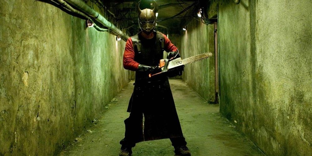 a man holding a chainsaw in a mask in Hostel