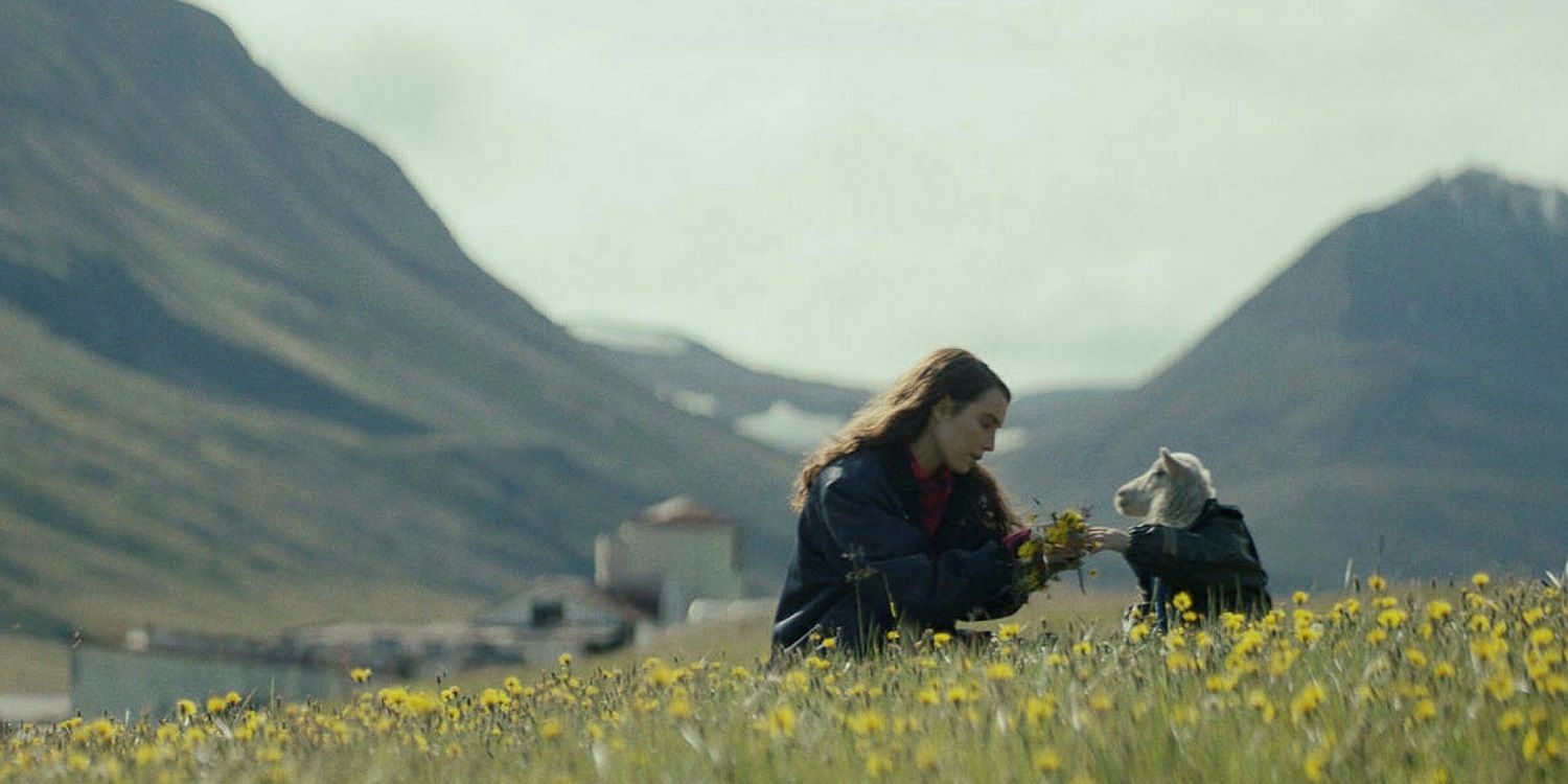 A lush meadow, a girl, and a lamb from A24's film, Lamb