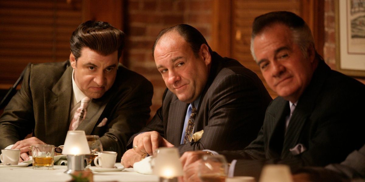Tony Soprano, played by James Gandolfini, sits at a table with Tony Sirico and Steven Van Zandt in The Sopranos.