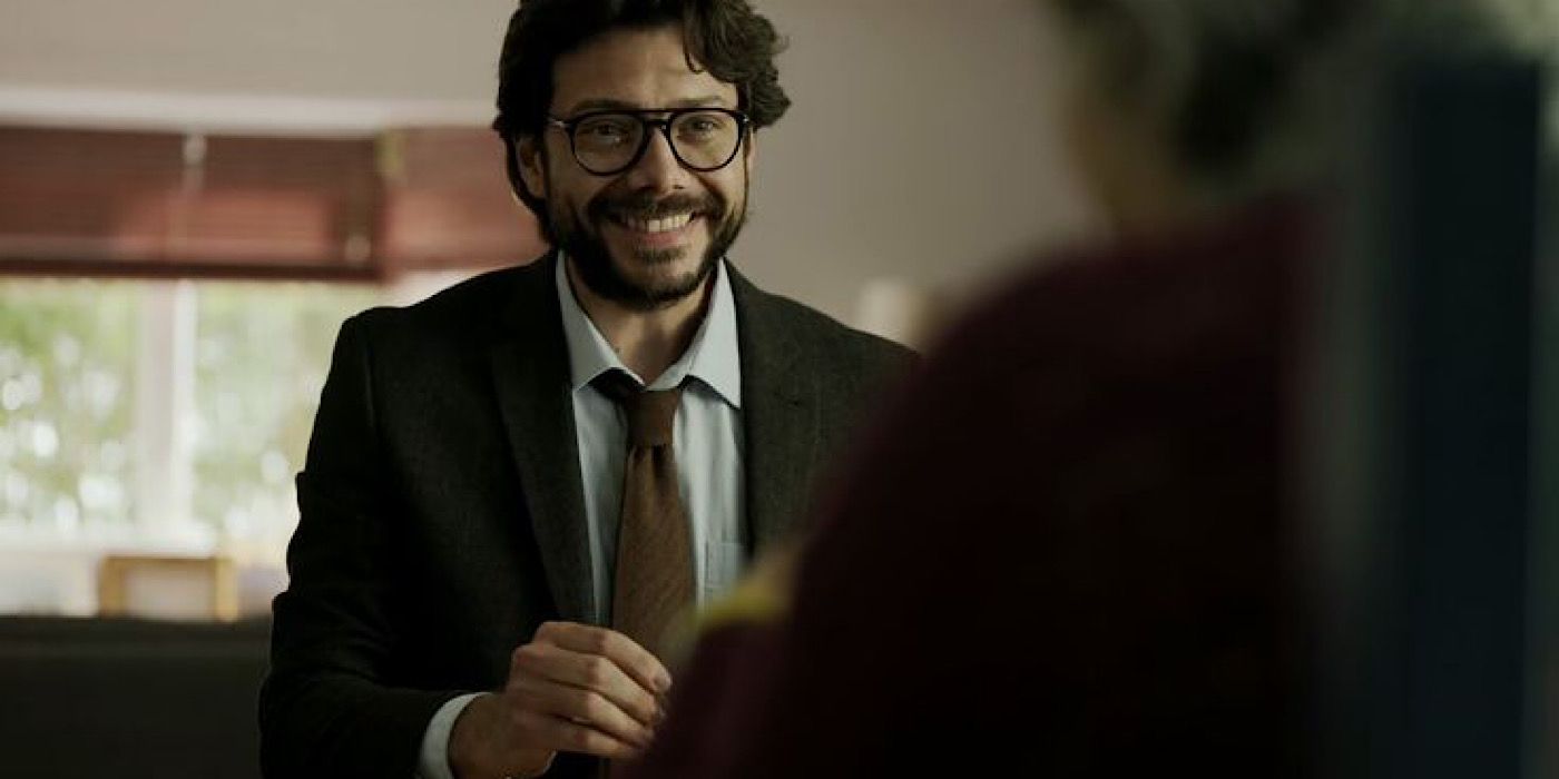 The Professor sits across from someone and smiles in Money Heist
