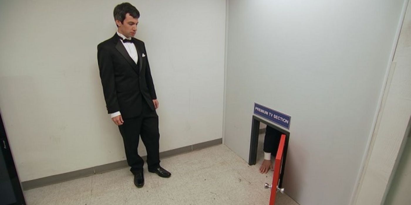 Nathan Fielder watches a man crawl through a tiny door on Nathan For You.