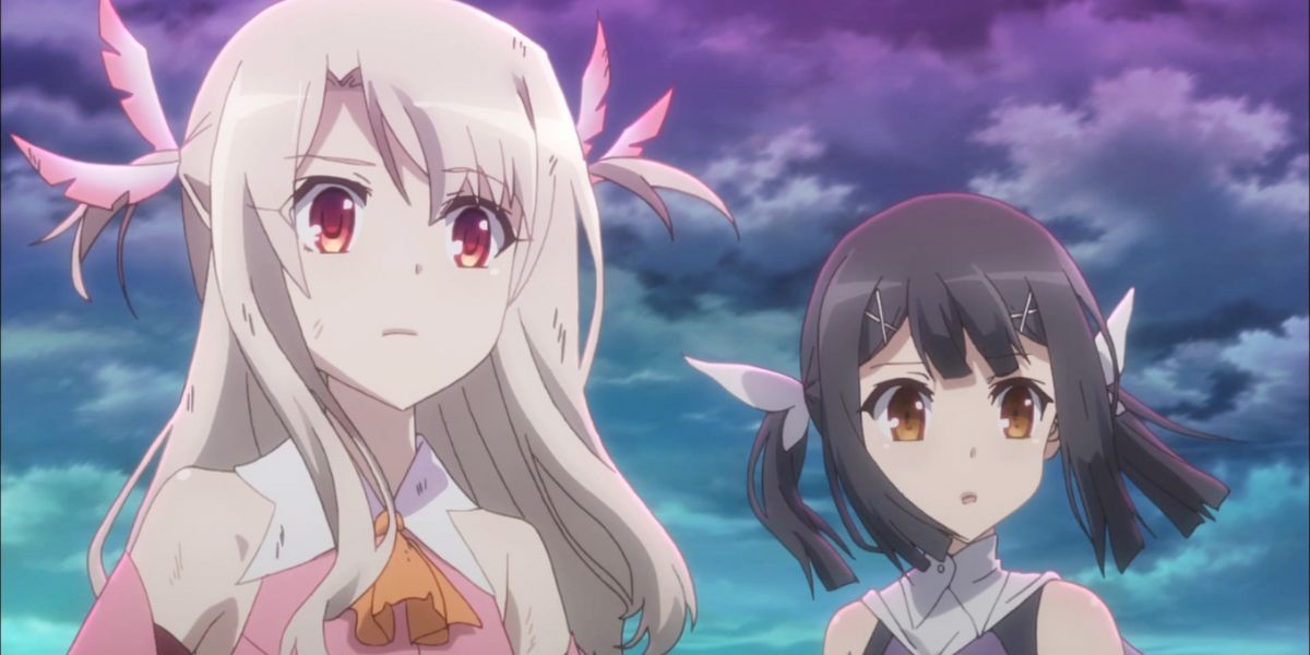 Image features a visual from Fate/kaleid liner PRISMA☆ILLYA: (From left to right) Both injured, Illyasviel von Einzbern (long, silver-blonde hair and pink dress) and Miyu Edelfelt (black pigtails and white ribbons) are looking forward.