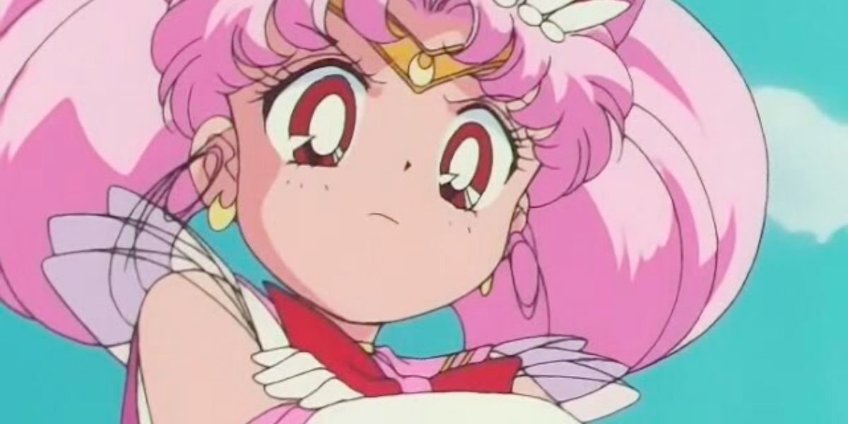 A imagem apresenta um visual de Sailor Moon: Chibiusa está cruzando os braços sobre o peito.