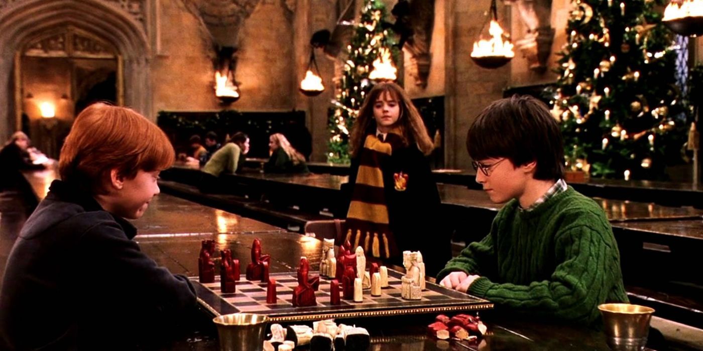 Ron and Harry playing Wizard's Chess at Christmas while Hermione walks up to them with her trunk in Harry Potter.