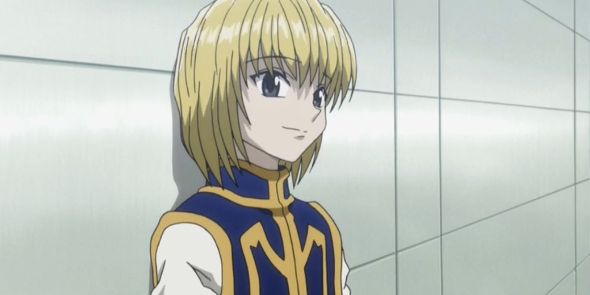 Kurapika smiling while leaning against a wall in Hunter x Hunter