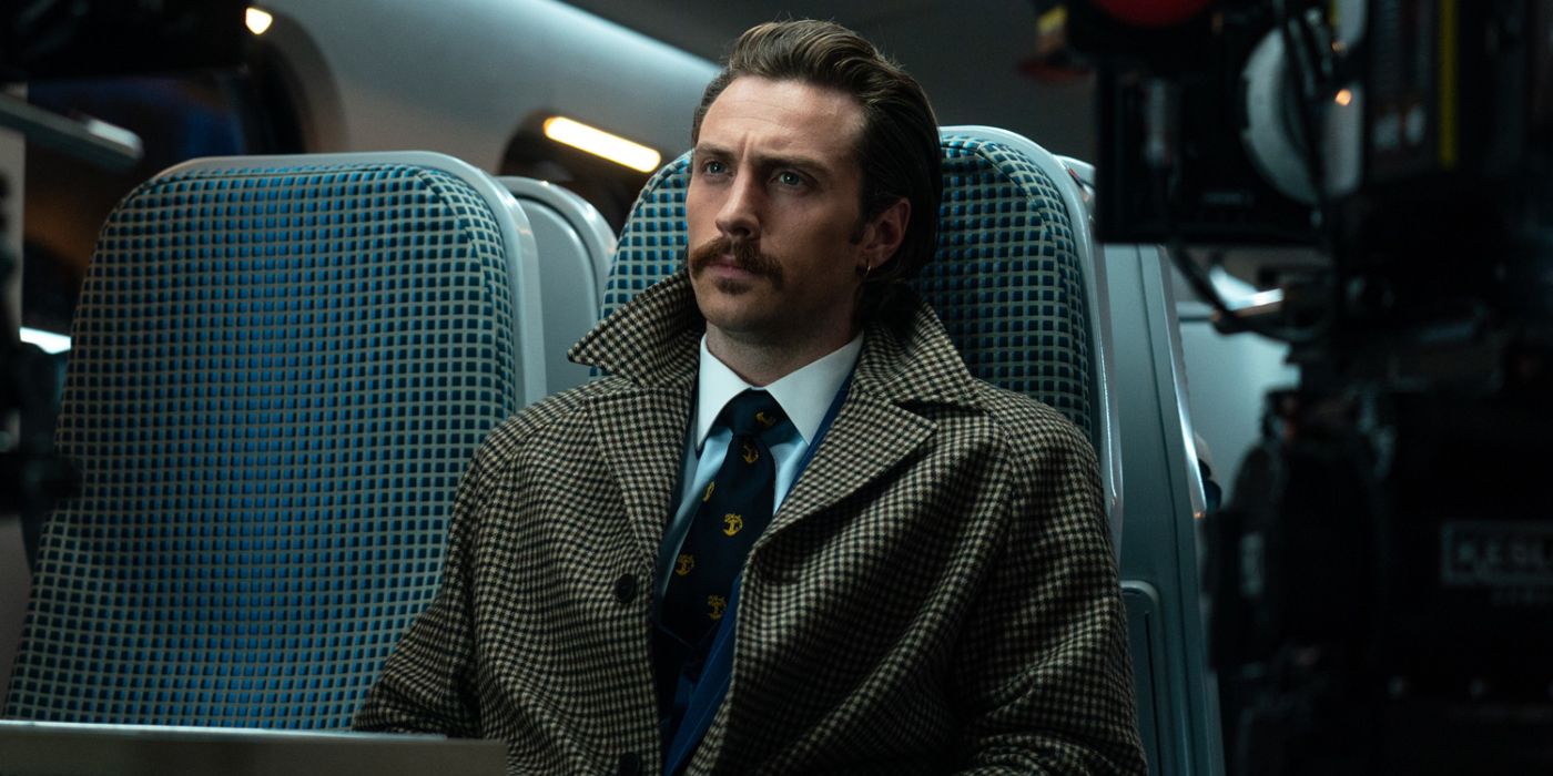 Aaron Taylor-Johnson sits on a train in Bullet Train.