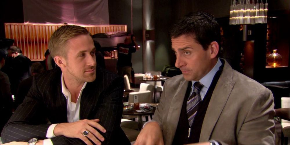 Ryan Gosling looks at Steve Carell while they sit at a table