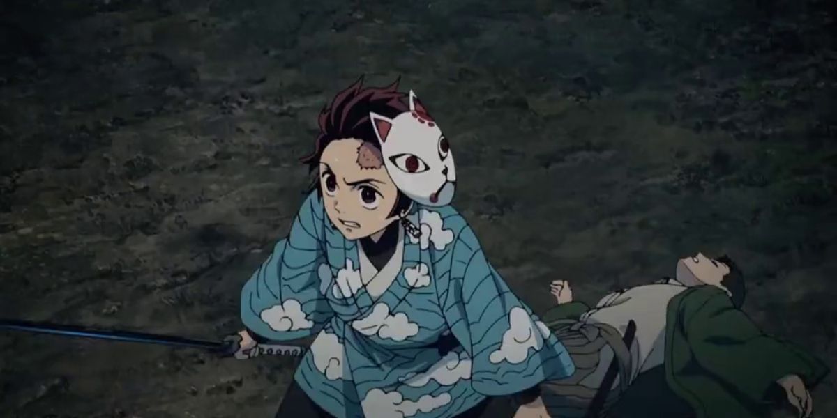 Tanjiro defending a boy on the ground in Demon Slayer.