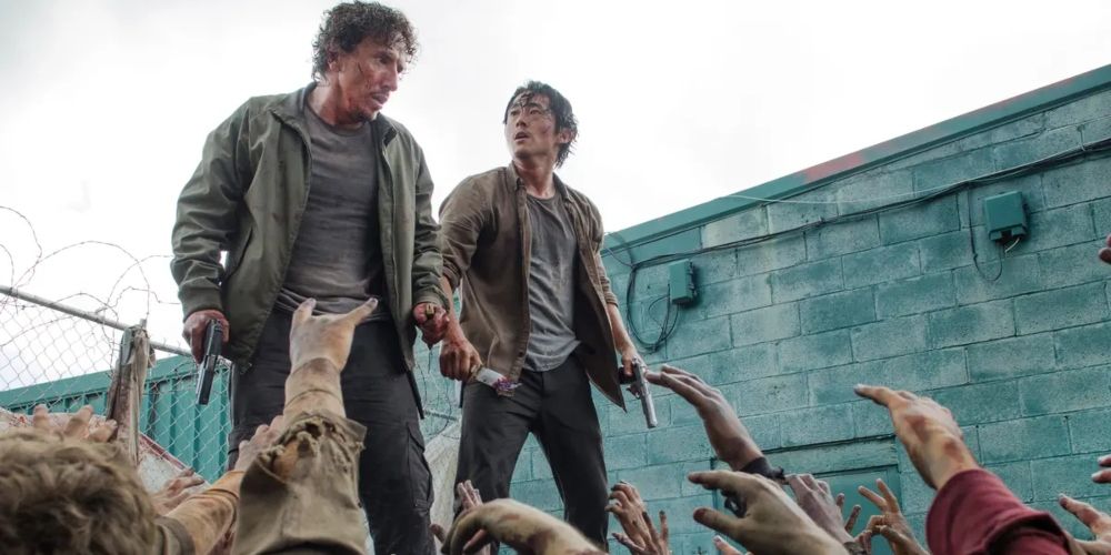 Glenn and Nicholas surrounded by walkers on a dumpster in The Walking Dead