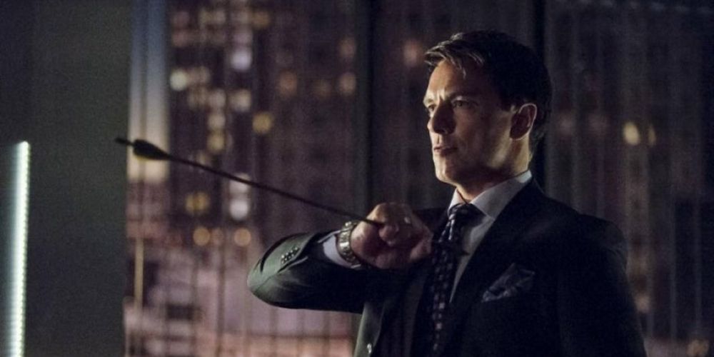 Malcolm Merlyn catches one of Oliver Queens' arrows in Arrow tv show