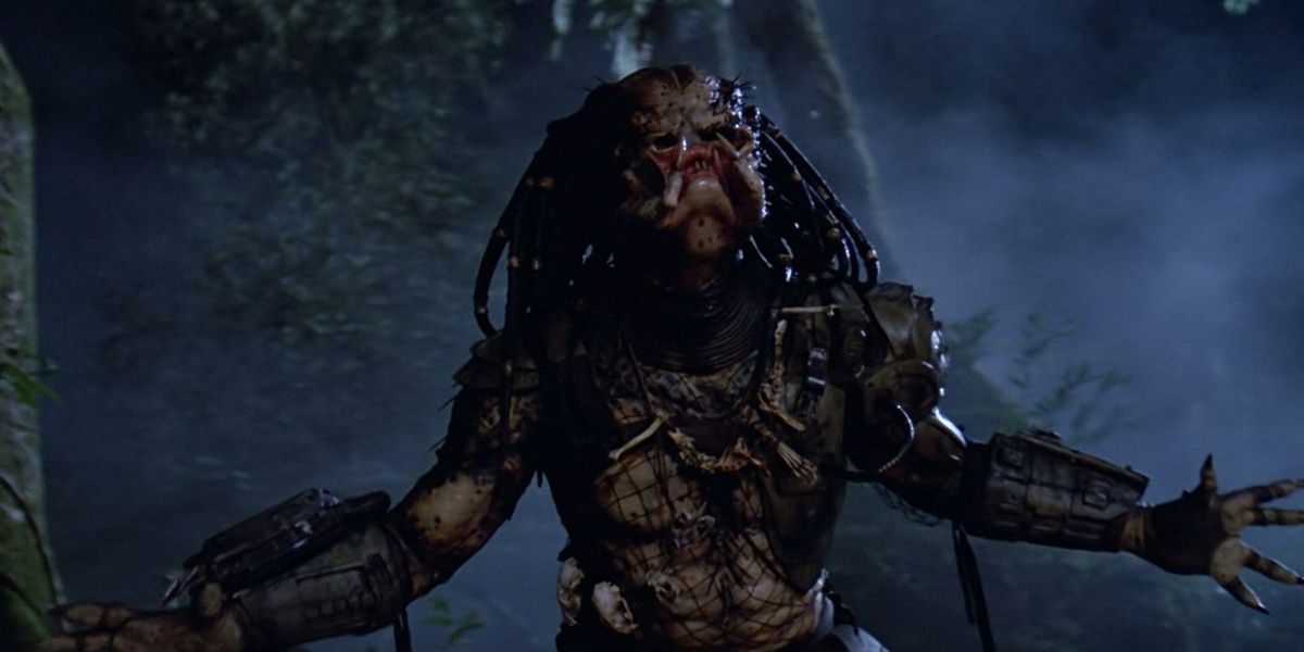 The Predator stands with its arms stretched open from the original film.