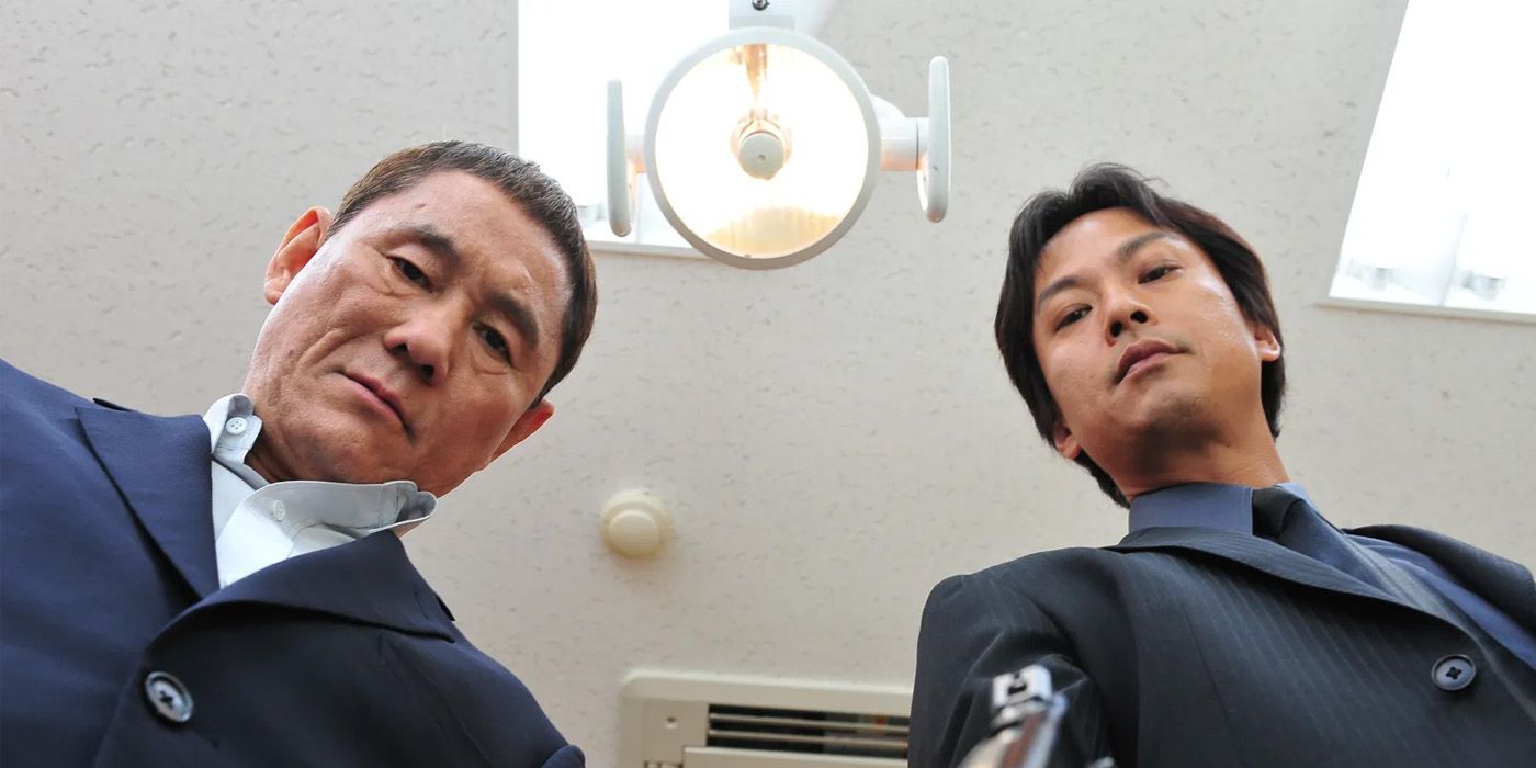 Takeshi Kitano olha para a câmera de um ângulo estranho