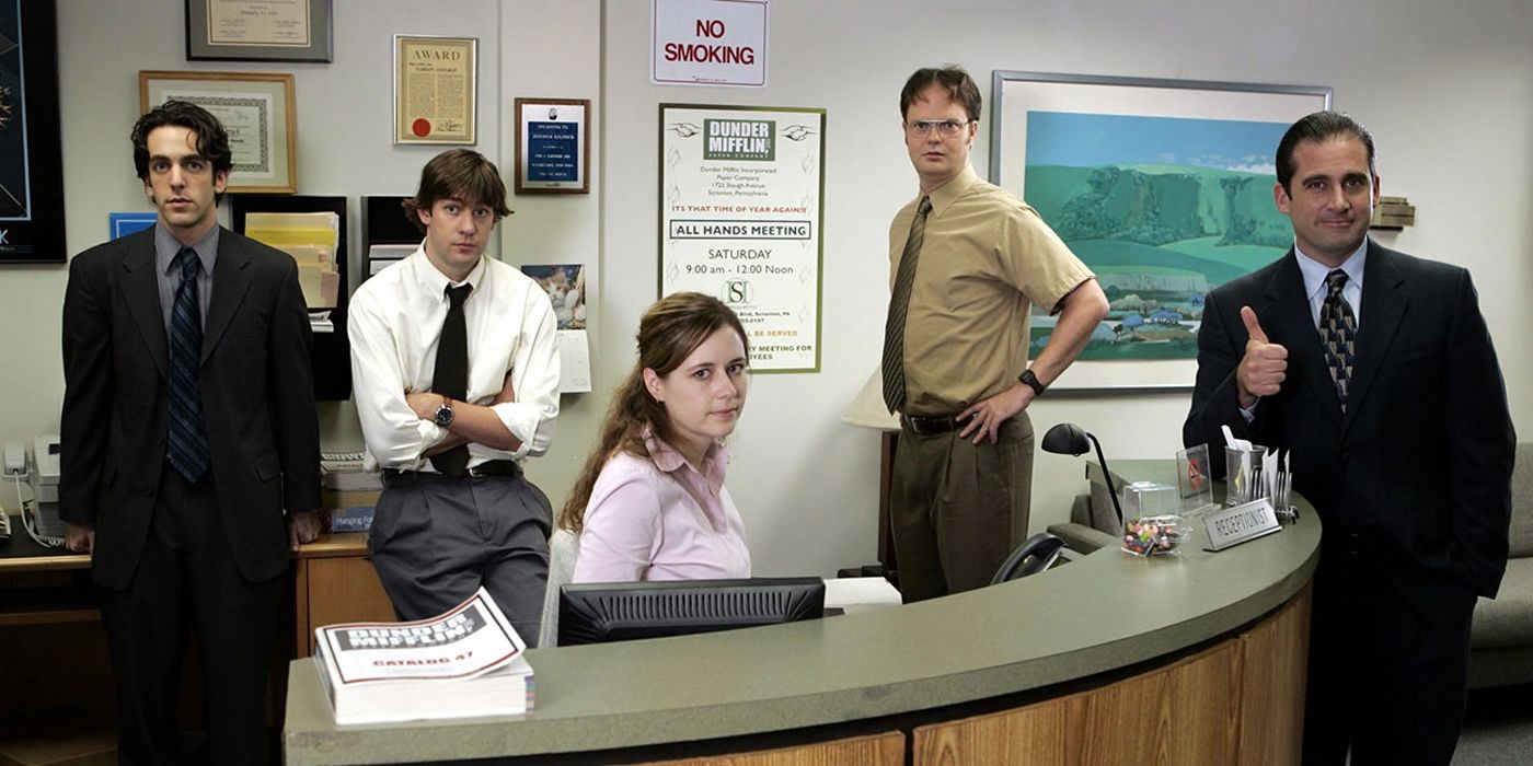 Ryan, Jim, Pam, Dwight e Michael do The Office, reunidos em volta da mesa de Pam e olhando para a câmera
