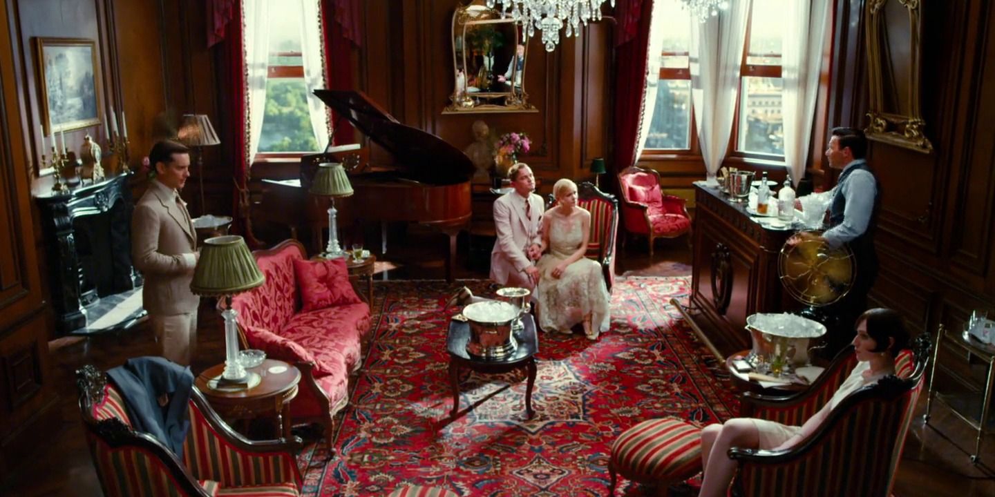 Gatsby and Daisy sit together while Tom stands to the right and Nick stands to the left in The Great Gatsby (2013).
