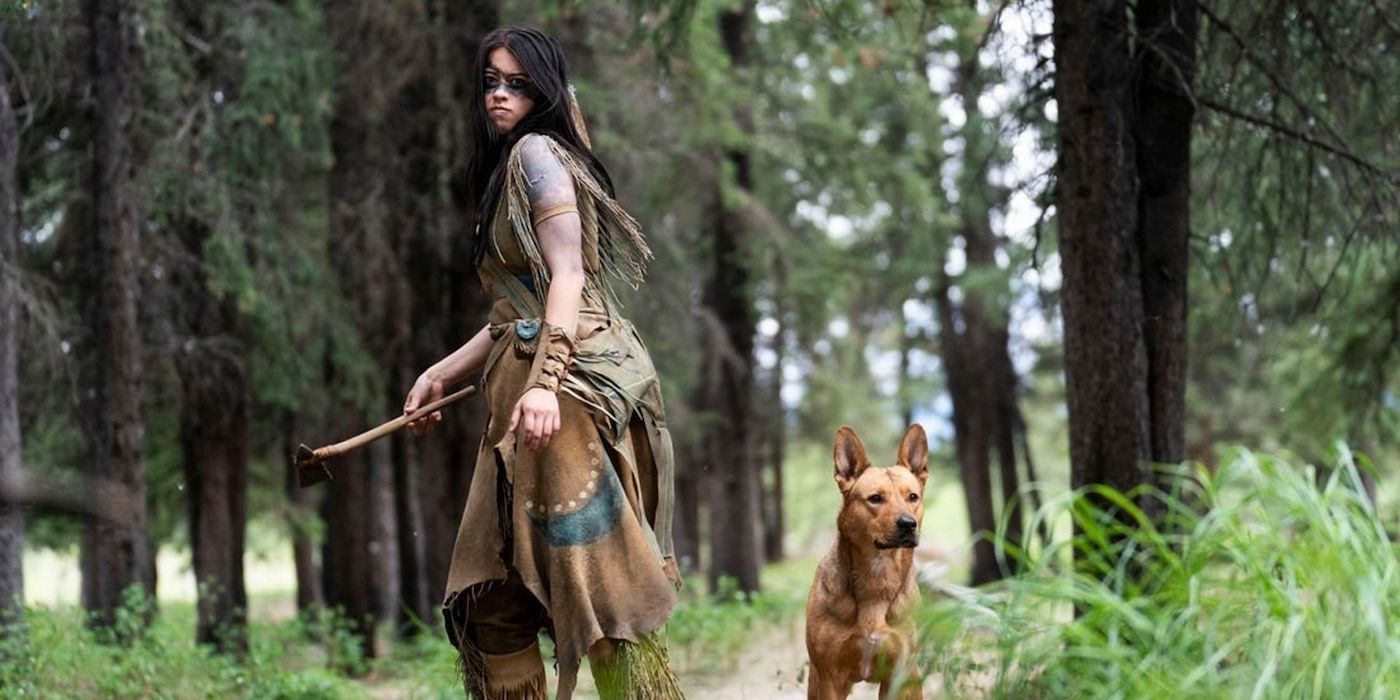 Naru walks through the woods with the dog, Sarii, in the movie Prey.