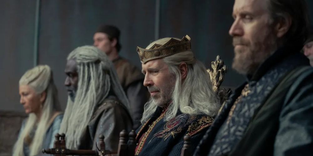 King Viserys I Targaryen sitting with members of his court in House of the Dragon