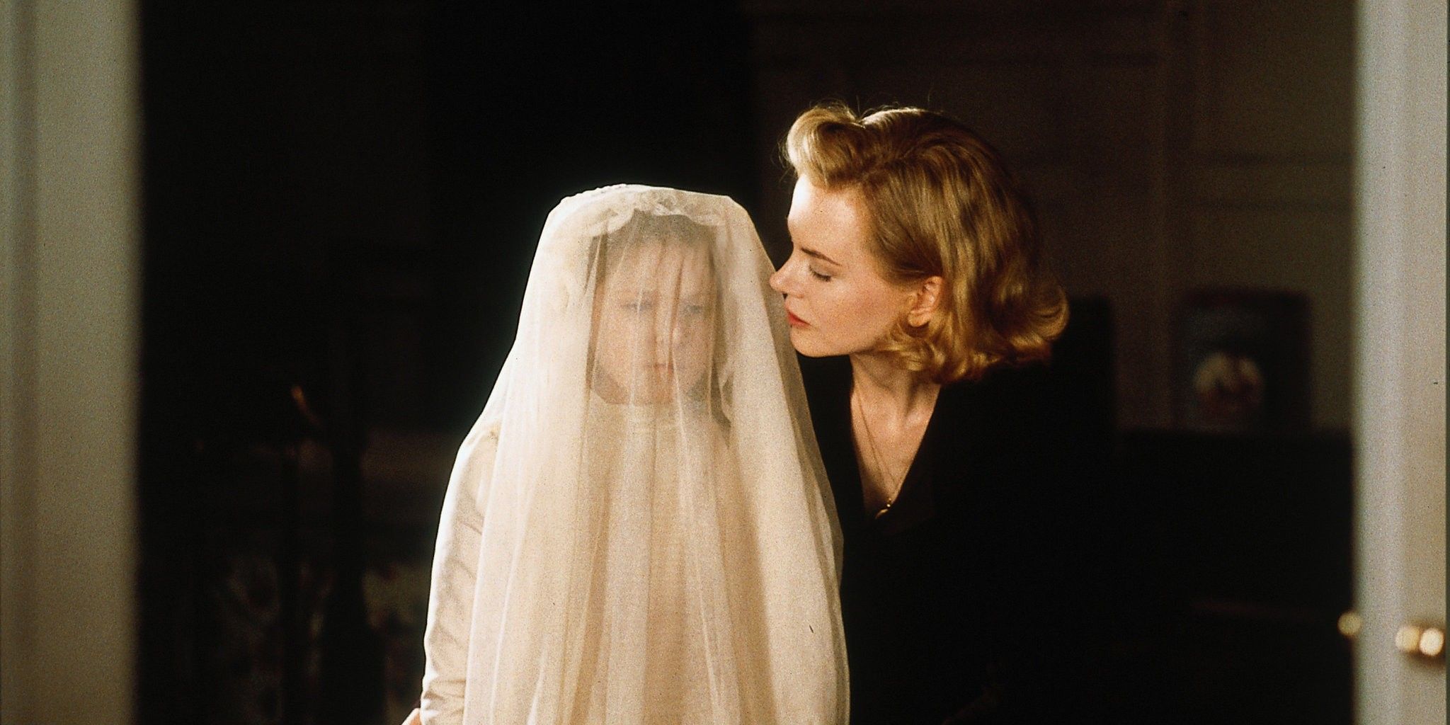 Grace dresses her daughter in her first communion dress in the horror film, The Others