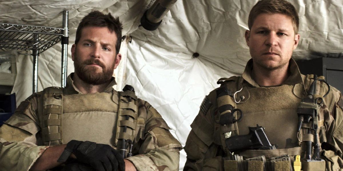 Chris Kyle (Bradley Copper) and Dauber (Kevin Lacz) standing in a tent in American Sniper.