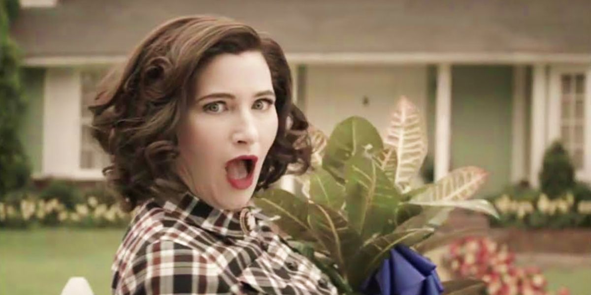 kathryn hahn as agatha in wandavision with mouth open and carrying plant