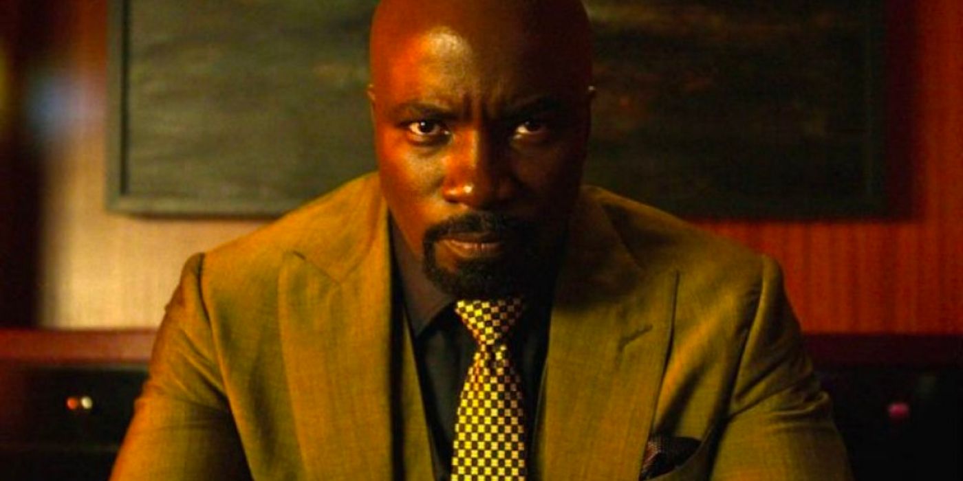 Luke Cage sits in Cottonmouth's old lair wearing a suit and tie.