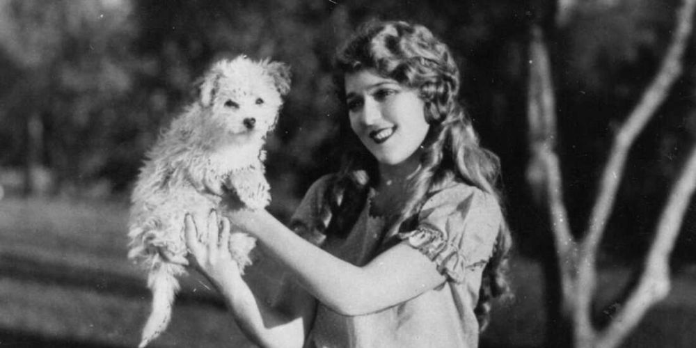 Mary Pickford playing with a dog