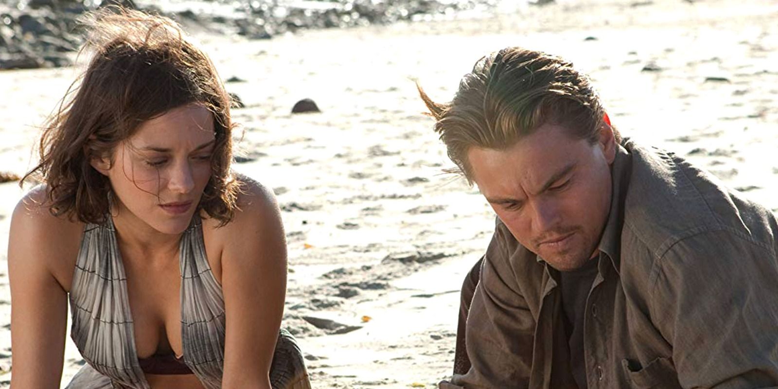 Mal and Dom Cobb sitting on a beach in Inception