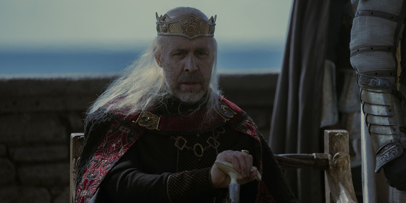 O Rei da Casa do Dragão, Viserys Targaryen, sentado com o mar atrás dele