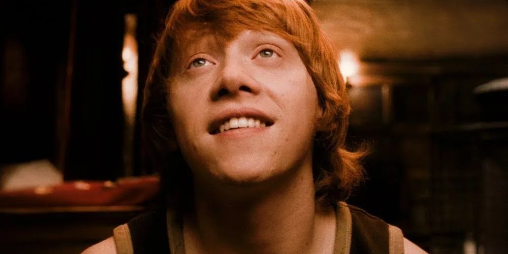 A close up of Ron Weasley looking up and smiling in Harry Potter and the Half-Blood Prince.