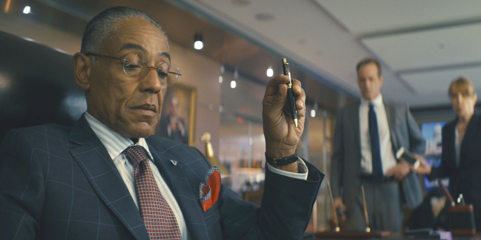 Giancarlo Esposito in The Boys sitting at a desk with a pen in his hand