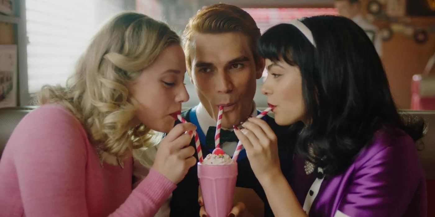Archie, Betty, and Veronica share a milkshake in 1955 in season seven of Riverdale