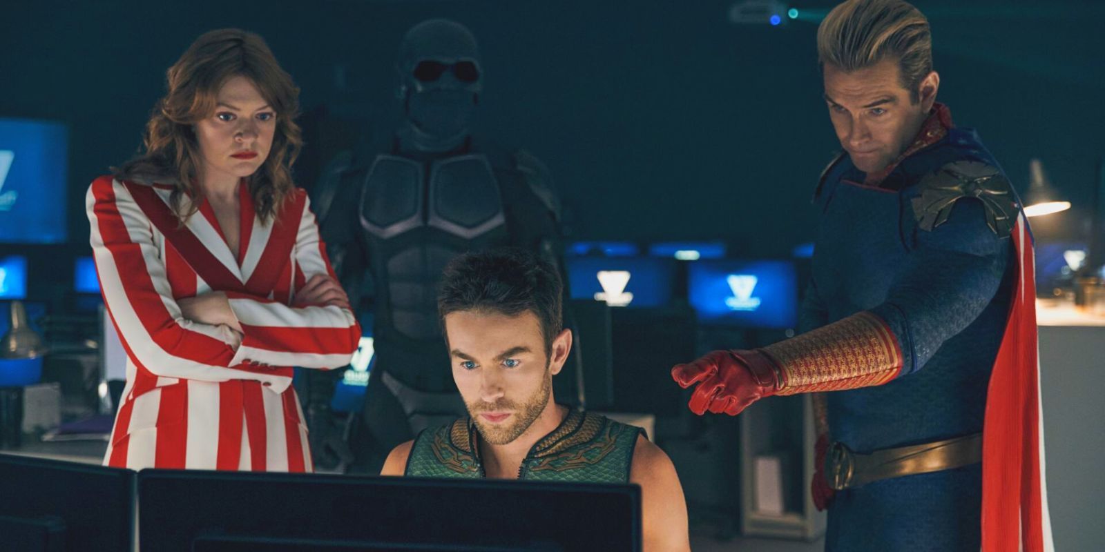 Various members of The Seven, including Black Noir and Homelander, standing around a computer