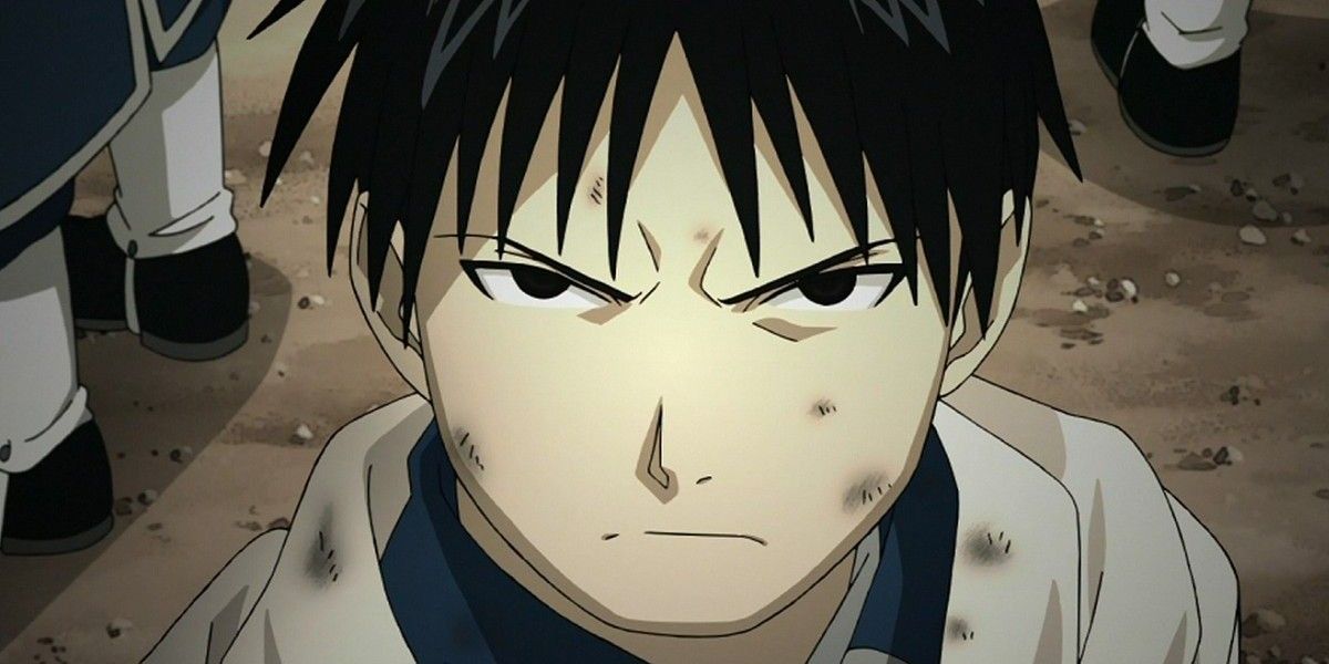 Young Roy Mustang with dirt on his face and scowling in Fullmetal Alchemist