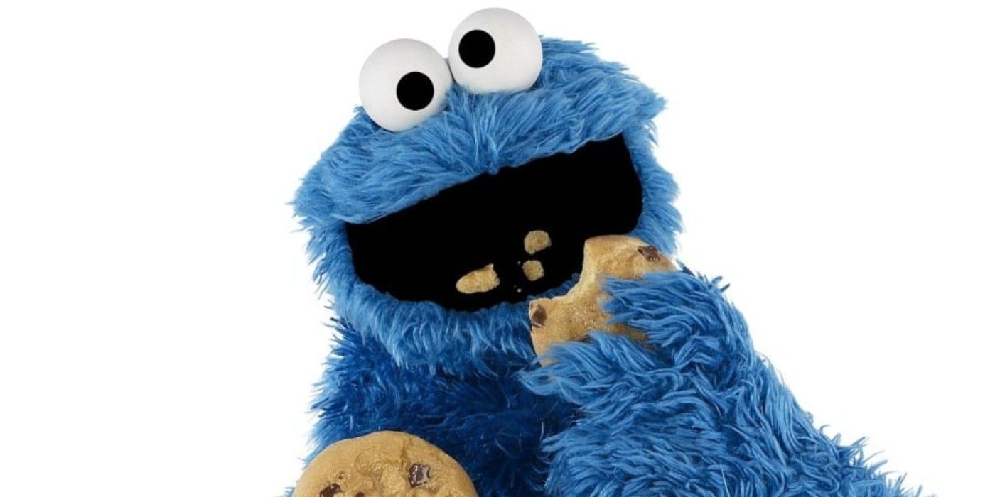 Sesame Street's Cookie Monster against a white background, eating chocolate chip cookies