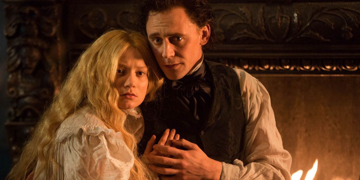 Edith and Thomas Sharpe hold each other by the fire in the film, Crimson Peak