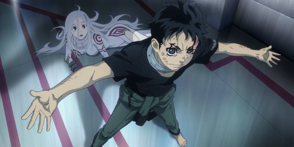 Ganta has his arms spread out protecting a girl on the floor in Deadman Wonderland.