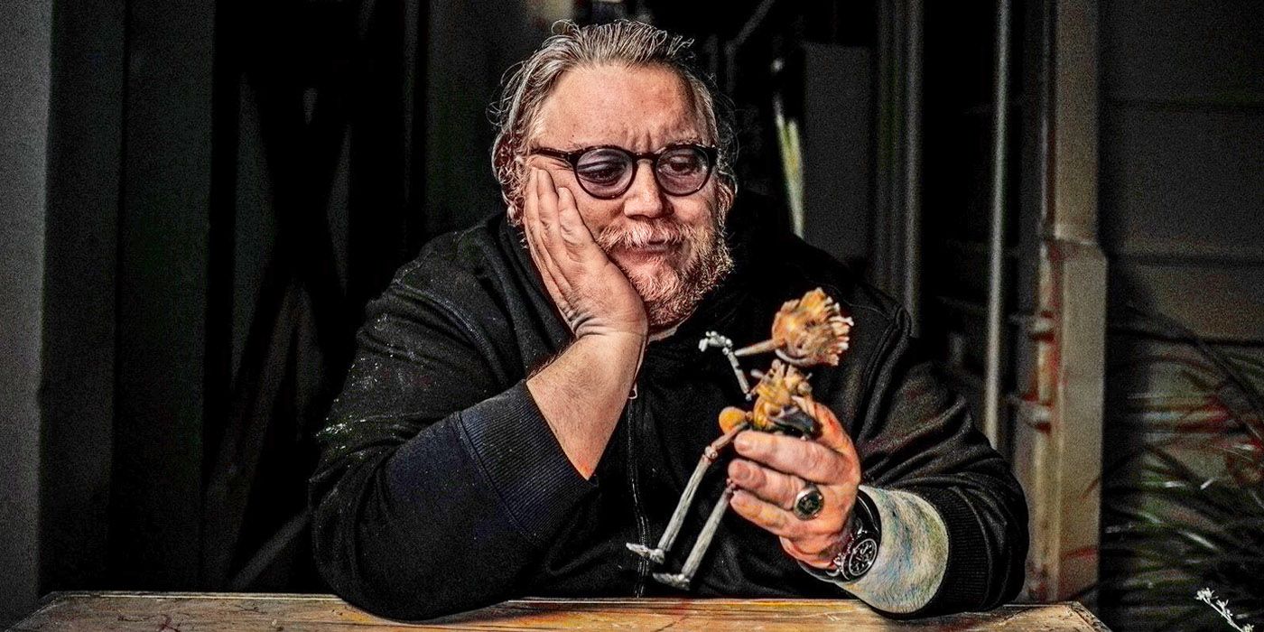 Guillermo del Toro holding a stop-motion figure of Pinocchio from his Netflix film.